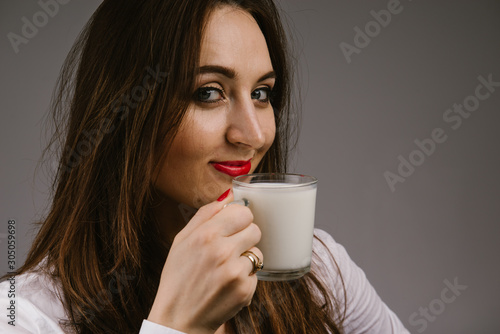 Cheerful girl holding milk mug in hand