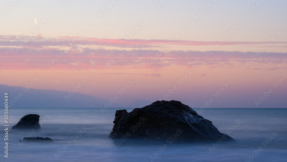 sea coast with stones at the sunrise, early morning long exposure scene