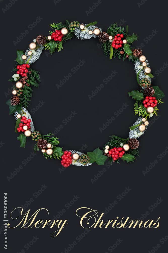 Merry Christmas wreath with winter flora & fauna & gold bauble decorations on dark grey background with copy space. Traditional festive theme with text title.