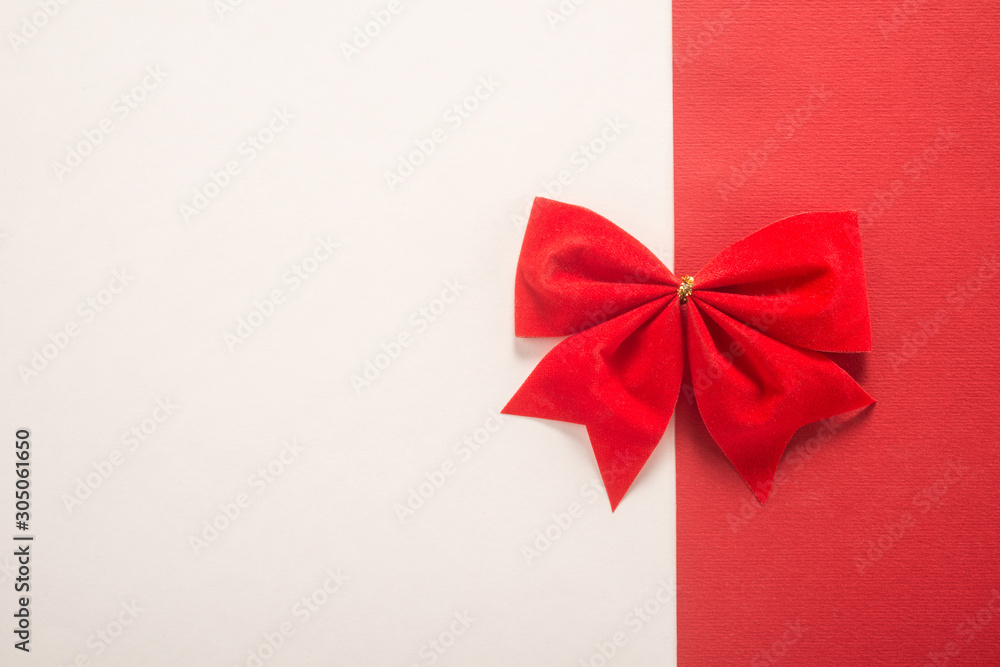 Red gift bow on white and red background