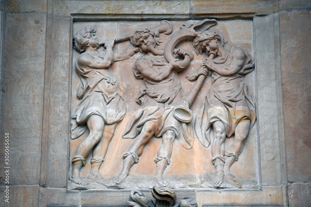 An old, weathered sandstone relief of trumpet playing angels in Potsdam-Germany. 