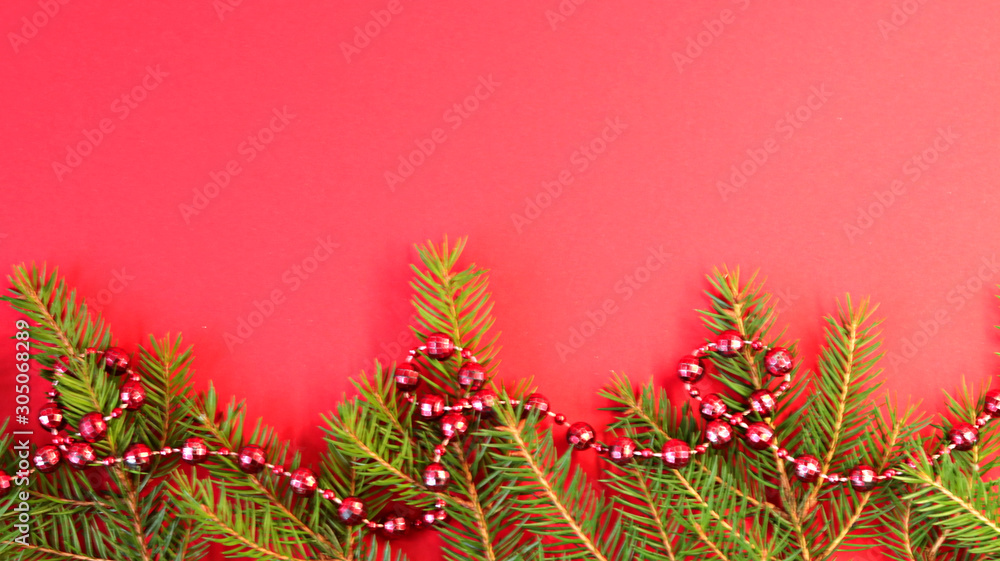 Christmas composition Christmas decorations, fir branches with a red background. Flat design, side view, copy space.