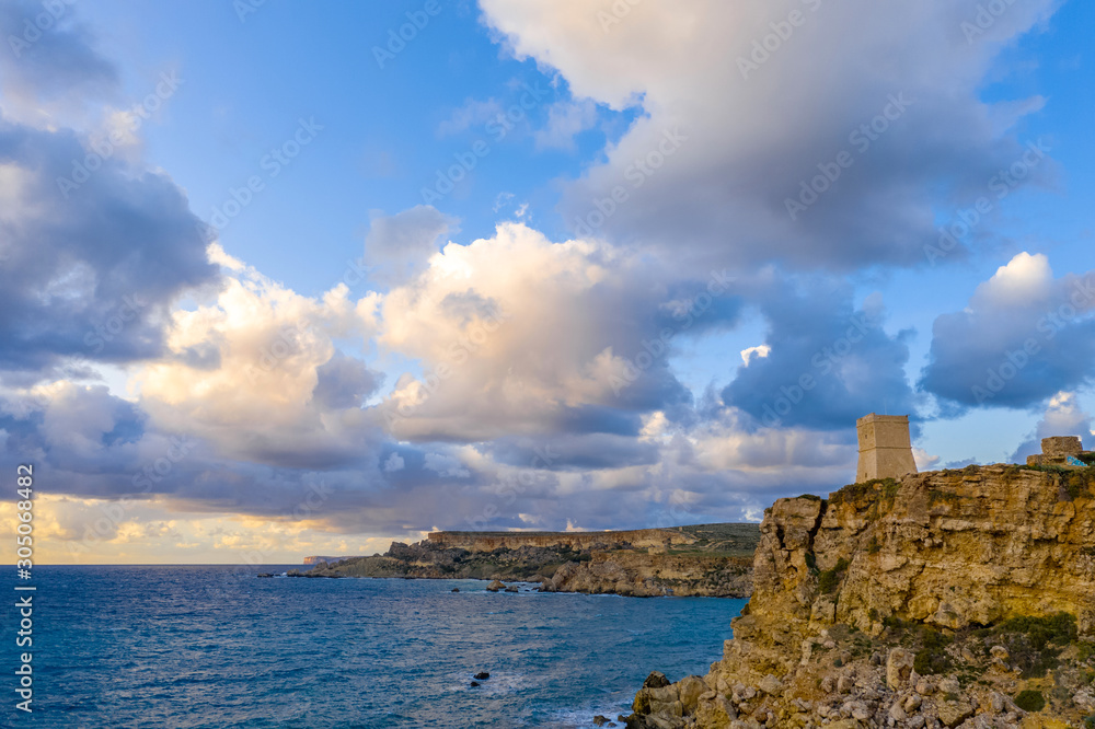 Ghajn Tuffieha Tower. Aerial view from the sea, sunset, cloudy blue sky. Landscape. Malta 