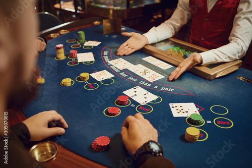 Hands of players and croupiers in the game cards. photo