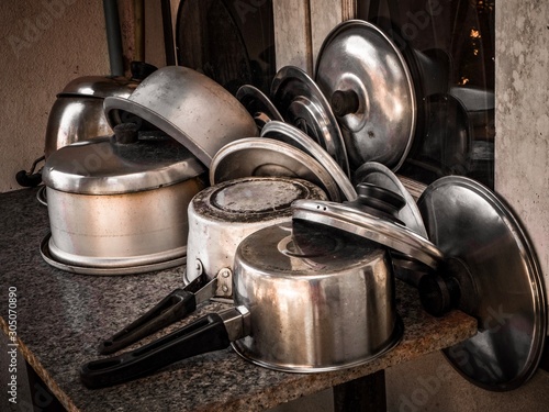 Many old stainless steel pots were laid upside down on the table.