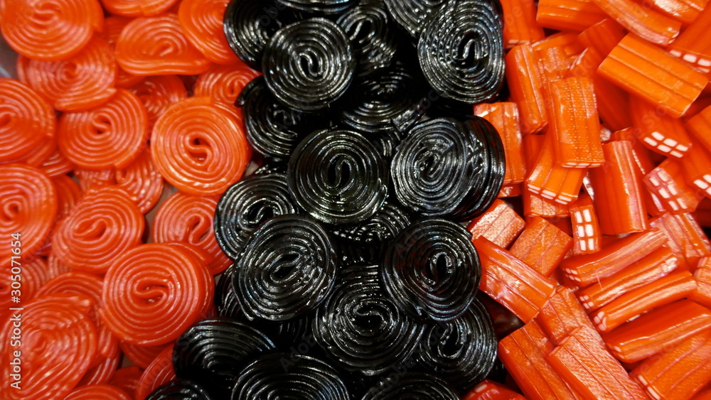 Fototapeta premium Licorice rolls, shiny, red and black. Background, Texture, Close-up, 