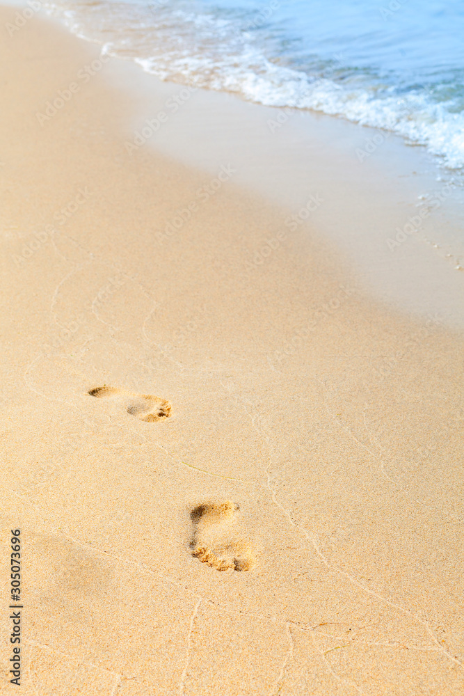 Footprints in the sand on a beach by the sea. Summer vacation concept. blue waves in the background. Relax on the sandy beach. Copy space. Footprints in the sand on a beach by the sea. Summer vacation concept. blue waves in the background. Relax on the sandy beach. Copy space.