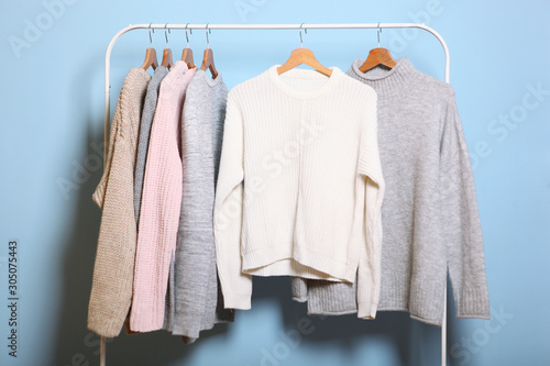 Wallpaper Mural Warm sweaters on a wardrobe hanger on a colored background. Autumn, winter clothes. Torontodigital.ca