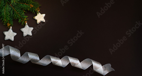 Christmas card concept with fir tree branches, silver star and spruce branches on dark background - text space. Merry Christmas and Happy Holidays. Flat lay, top view.