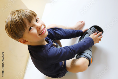 Ein dreijähriger Junge trägt eine Fußorthese