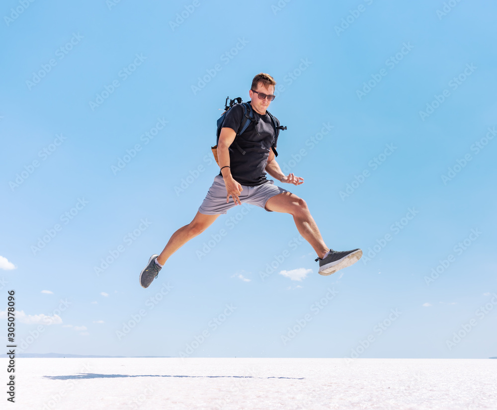 Traveling man jumping like a rock star at Tuz salt lake, Turkey. Rock and roll style concept.