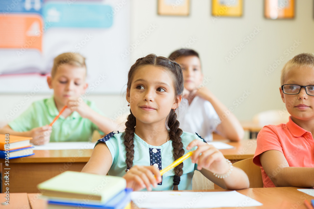 Fototapeta premium Sprytne dzieci w wieku szkolnym uczące się i w klasie w szkole