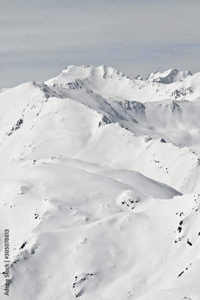 Blick von der Axamer Lizum in Tirol auf die schneebedeckten Berge und Gipfel. Neuschnee im Winter. Steile Hänge mit viel Schnee