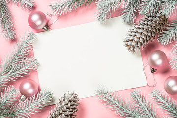 Christmas greeting card with empty blank sheet, fir tree and decorations on pink.