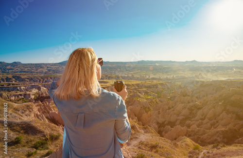 Woman enjoying scenic view with cup of coffee.