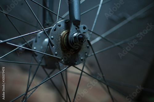 Grey rusted spokes of a antique bicycle.