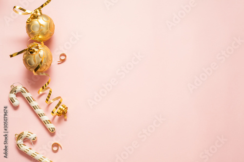 Christmas background for text, pink color, decorated with gold Christmas toys, bows and candies. The concept of a New year or Christmas. © Карина Желнина