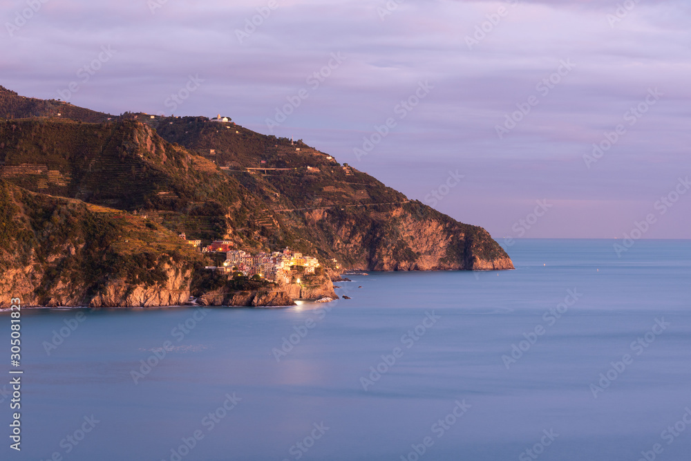  View of Manarola in Sunset's Cinque Terre National Park, calm sea on orange slopes of mountains