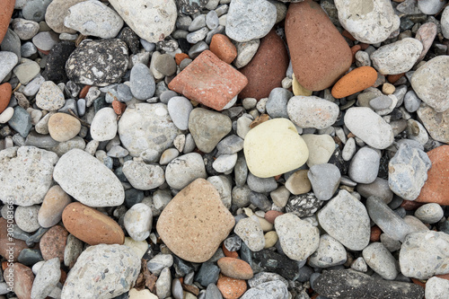 Pebbles on the beach in various colours and random sizes