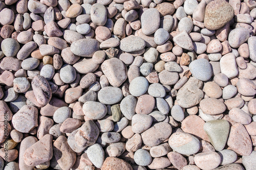 Pebbles on the beach in various colours and random sizes