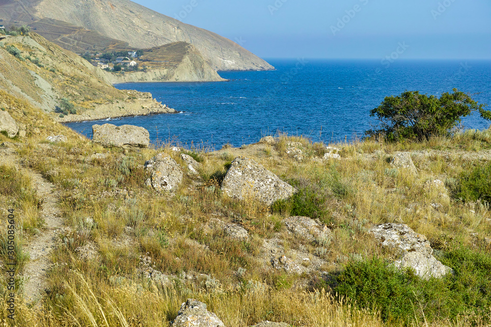 Cape Black sea in the village of Ordzhonikidze in the Crimea, in the summer with a textured sky with clouds. And hilly terrain, landscape