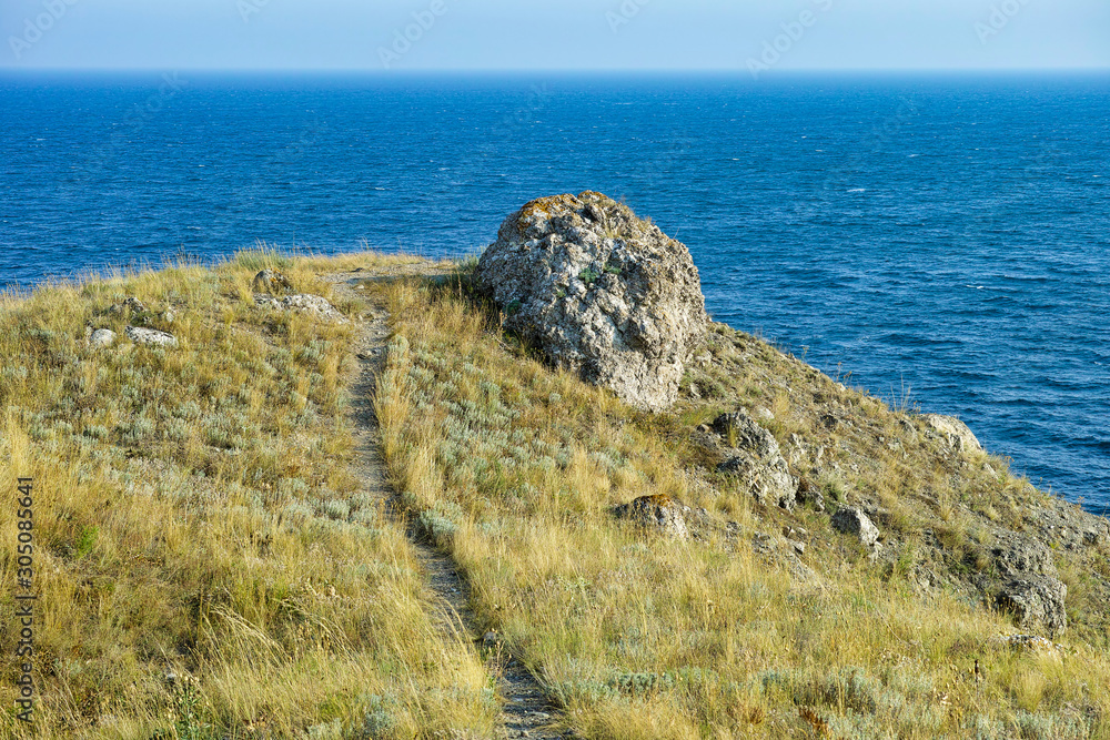 Cape Black sea in the village of Ordzhonikidze in the Crimea, in the summer with a textured sky with clouds. And hilly terrain, landscape