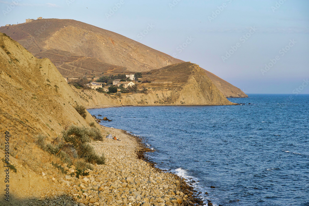 Cape Black sea in the village of Ordzhonikidze in the Crimea, in the summer with a textured sky with clouds. And hilly terrain, landscape