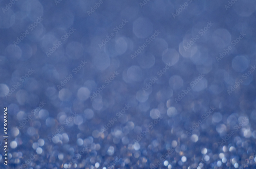 Abstract New Year blue bokeh background with shining defocus sparkles. Blurred glitters shimmering dust macro close up, copy space for text logo Abstract New Year blue bokeh background with shining defocus sparkles. Blurred glitters shimmering dust macro close up, copy space for text logo