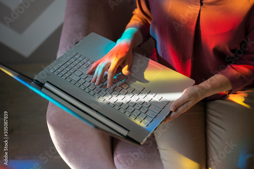 Woman sitting on sofa and using laptop