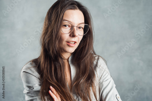 Young brunette woman in glasses, self-confidence. Smiling and calm girl