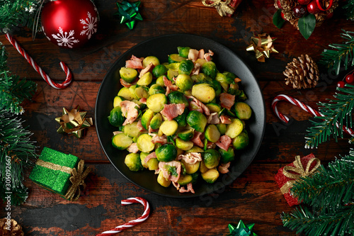 Christmas Brussel Sprouts and Bacon with decoration, gifts, green tree branch on wooden rustic table