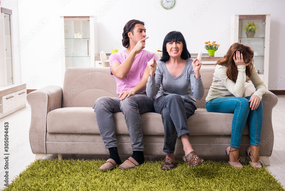 Young family and mother-in-law in family issues concept Young family and mother-in-law in family issues concept