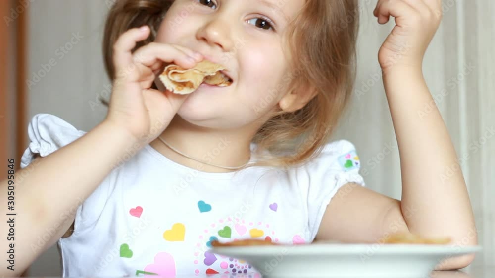 Baby girl eating pancakes. Child eating breakfast. Baby girl eating pancakes. Child eating breakfast.