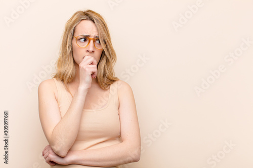 Fotografía young pretty blonde woman with surprised, nervous, worried or frightened look, l