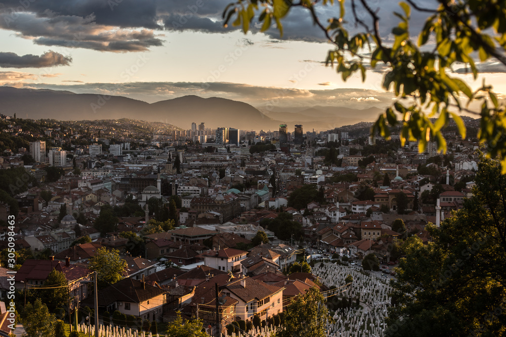 Arial view of a city from a hill during sunset, Sarajevo Bosnia and Herzegovina. The whole city with mountains layers in the background.