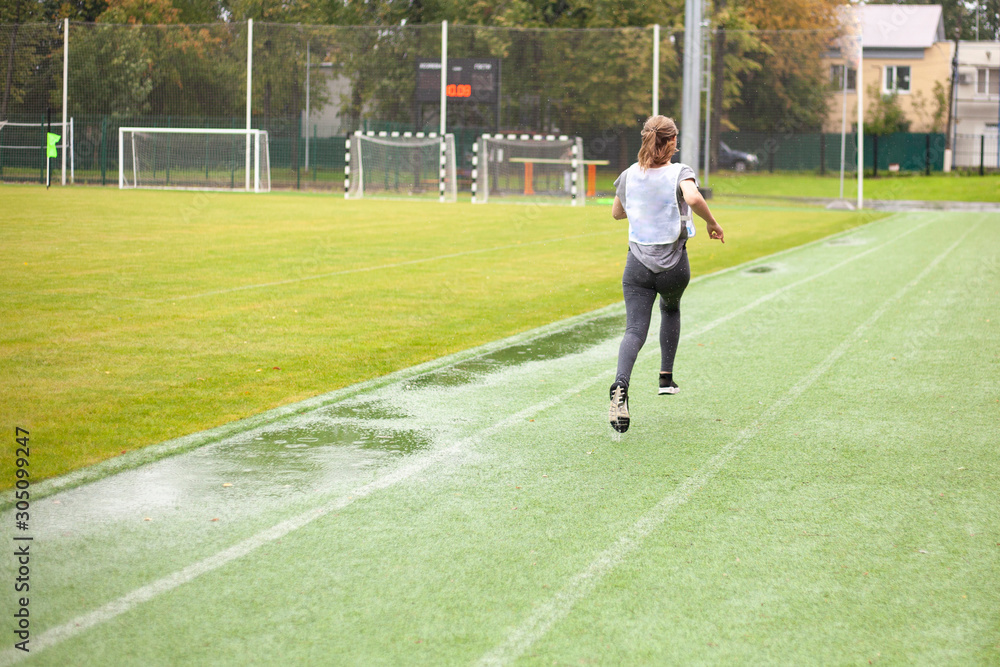 Obraz premium The girl runs on time. Competition in the stadium.