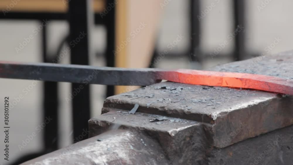 A blacksmith forge by hammer hot iron bar to make a horseshoe. Forging on iron anvil with a hammer. A blacksmith forge by hammer hot iron bar to make a horseshoe. Forging on iron anvil with a hammer.