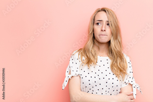 Fotografía young pretty blonde woman doubting or thinking, biting lip and feeling insecure