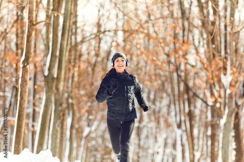 Girl jogging in the snow on the nature in winter