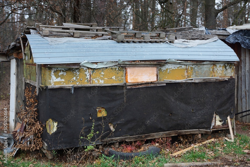 one old black trailer with a small window stands in nature in the autumn park one old black trailer with a small window stands in nature in the autumn park