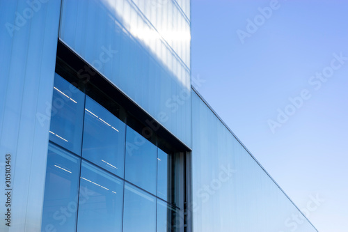 modern building with blue sky and clouds reflected in windows