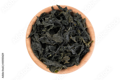 Dried kombu seaweed in wooden bowl isolated on white background. top view. spices and food ingredients