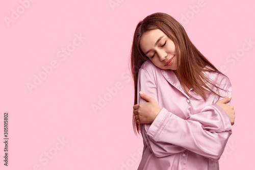Young woman embracing body during sleep photo