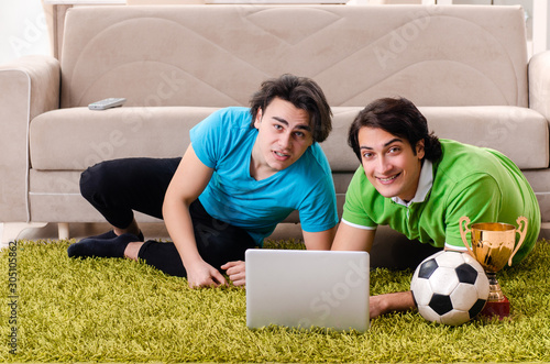 Friends watching football at home