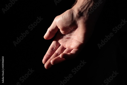 Men's palm in full dark under studio lighting, or "Helping Hand"