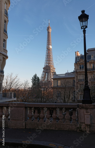 View of the Eiffel Tower from a small cobbled dead-end street at sunny autumn afternoon. Paris.