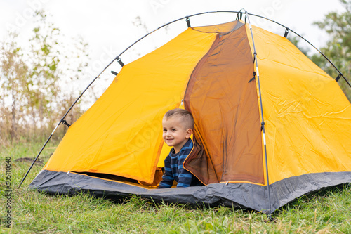 Little boy in a tent. Camping in the nature.