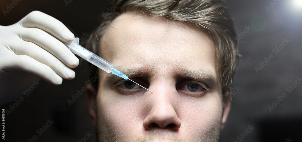 Obraz premium man is undergoing Botox treatment in a beauty clinic. Nasal bridge injection.