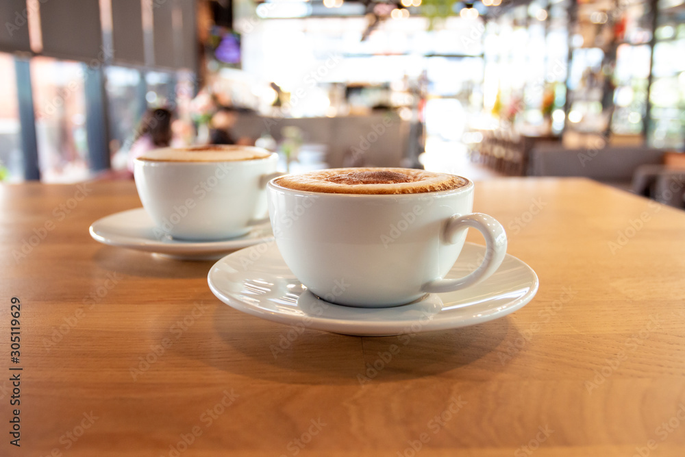 Fototapeta Filiżanka pachnącej kawy cappuccino. O poranku w kawiarni kawa orzeźwia ciało.
