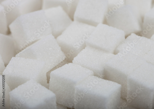 Close-Up shot of natural white sugar cubes on white background.
